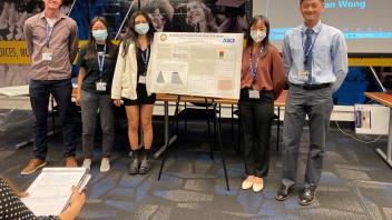 A group of students presenting a poster at the Midpac conference
