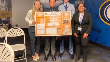 Students presenting their poster at the Midpac conference