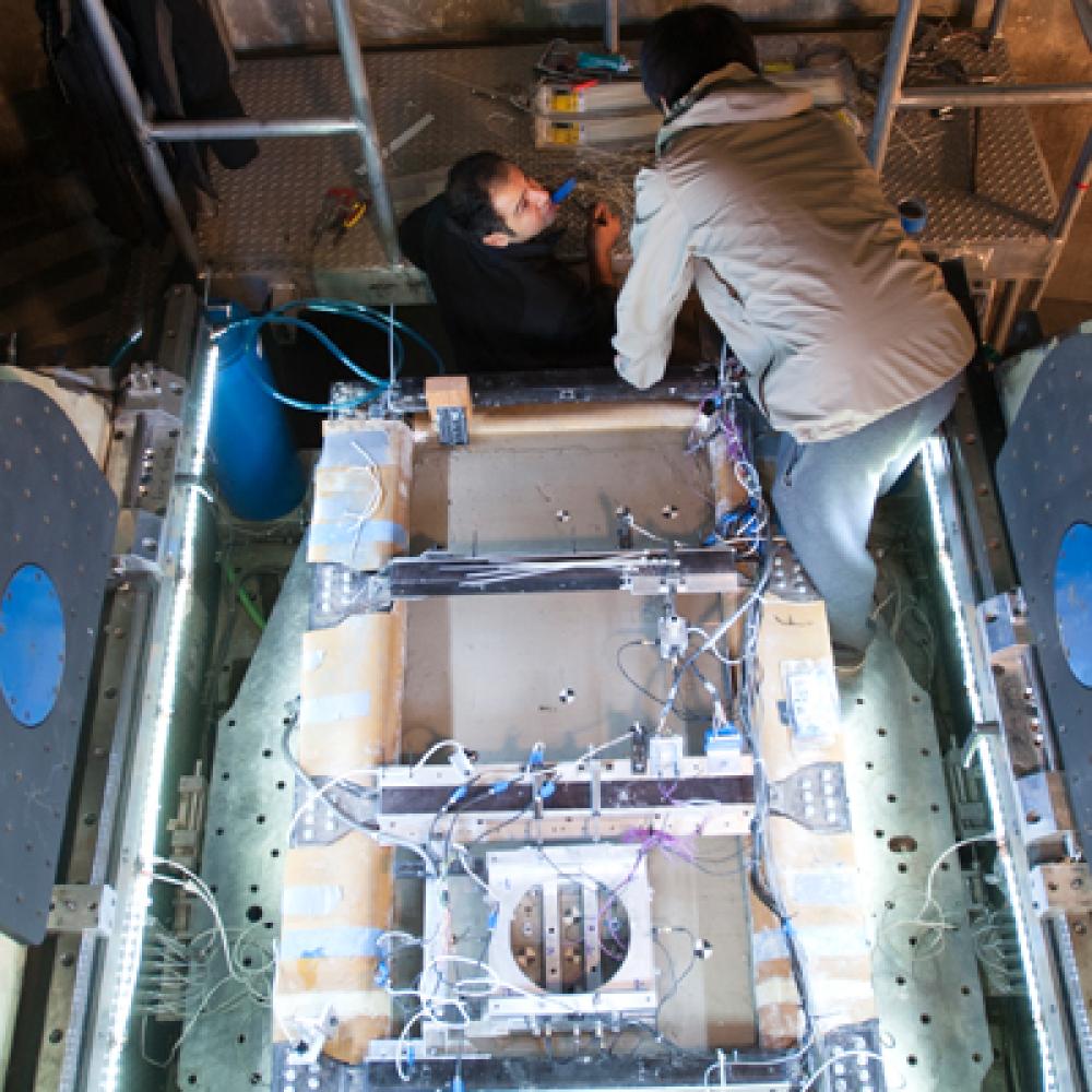 Two researchers on top of geotech machine 