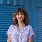 Somayeh Nassiri wearing a striped shirt against a corrugated wall