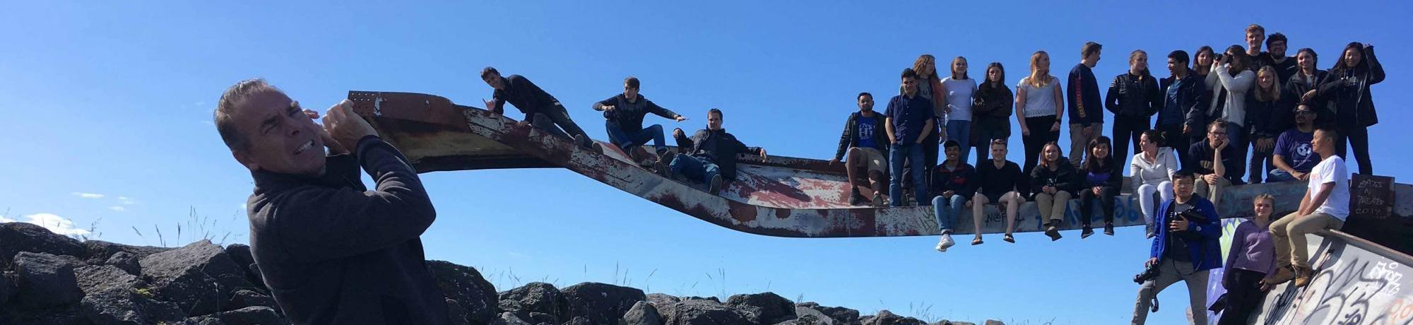 students sitting on a structure for a group photo