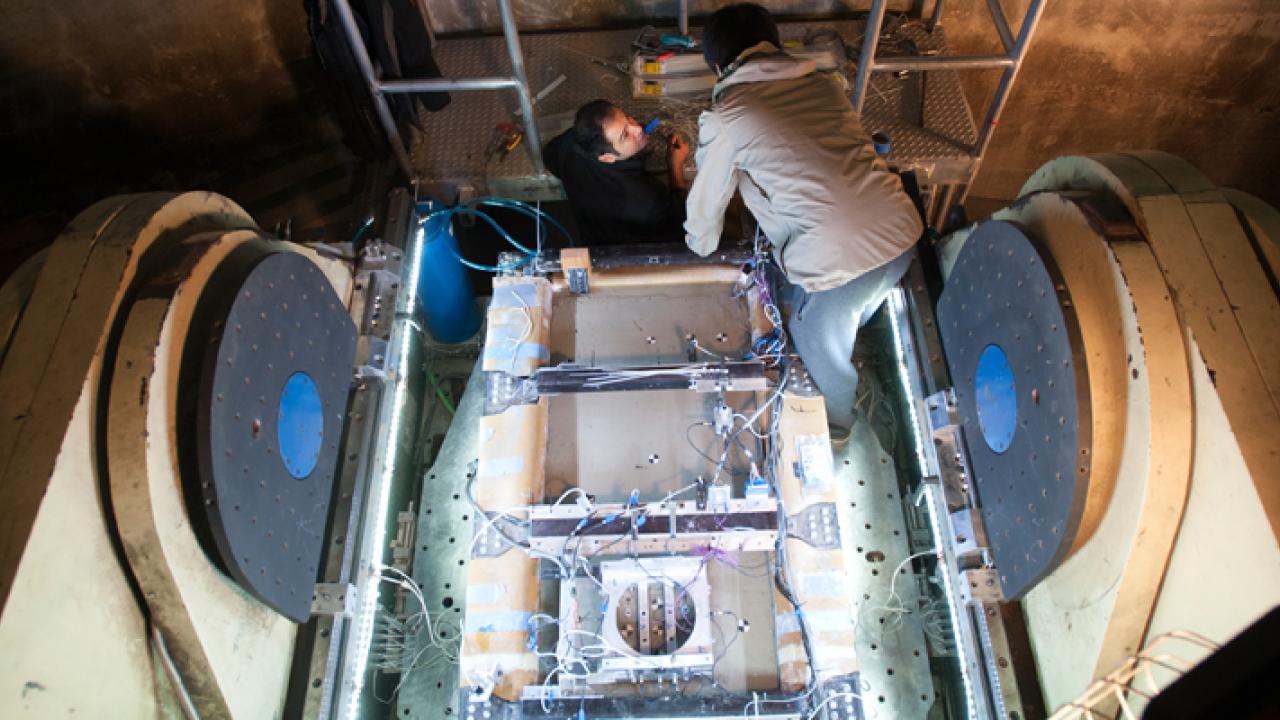 Two researchers on top of geotech machine 