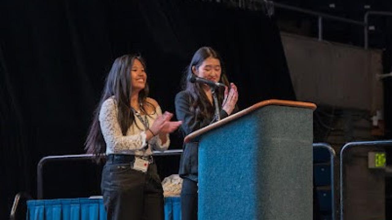 Two students speaking at a podium