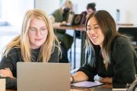 students looking over laptop